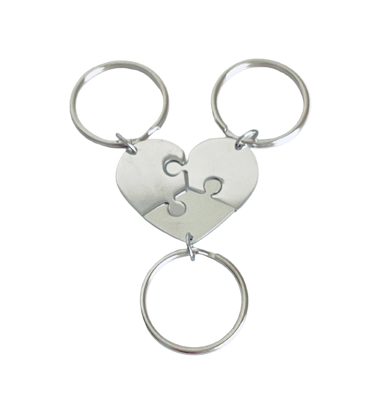 A three-ring metal keychain set featuring a puzzle heart charm in the center, with two interlocking heart halves and two separate circular key rings, shown on a plain white background.