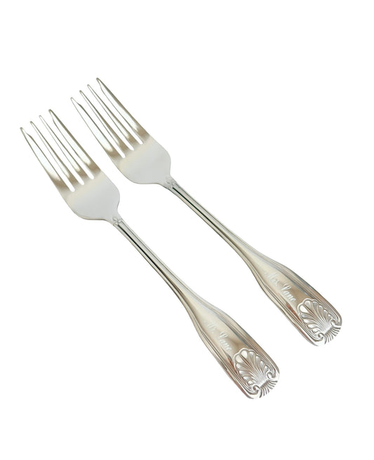 Two silver flatware forks with ornate handles, arranged diagonally on a plain white background.
