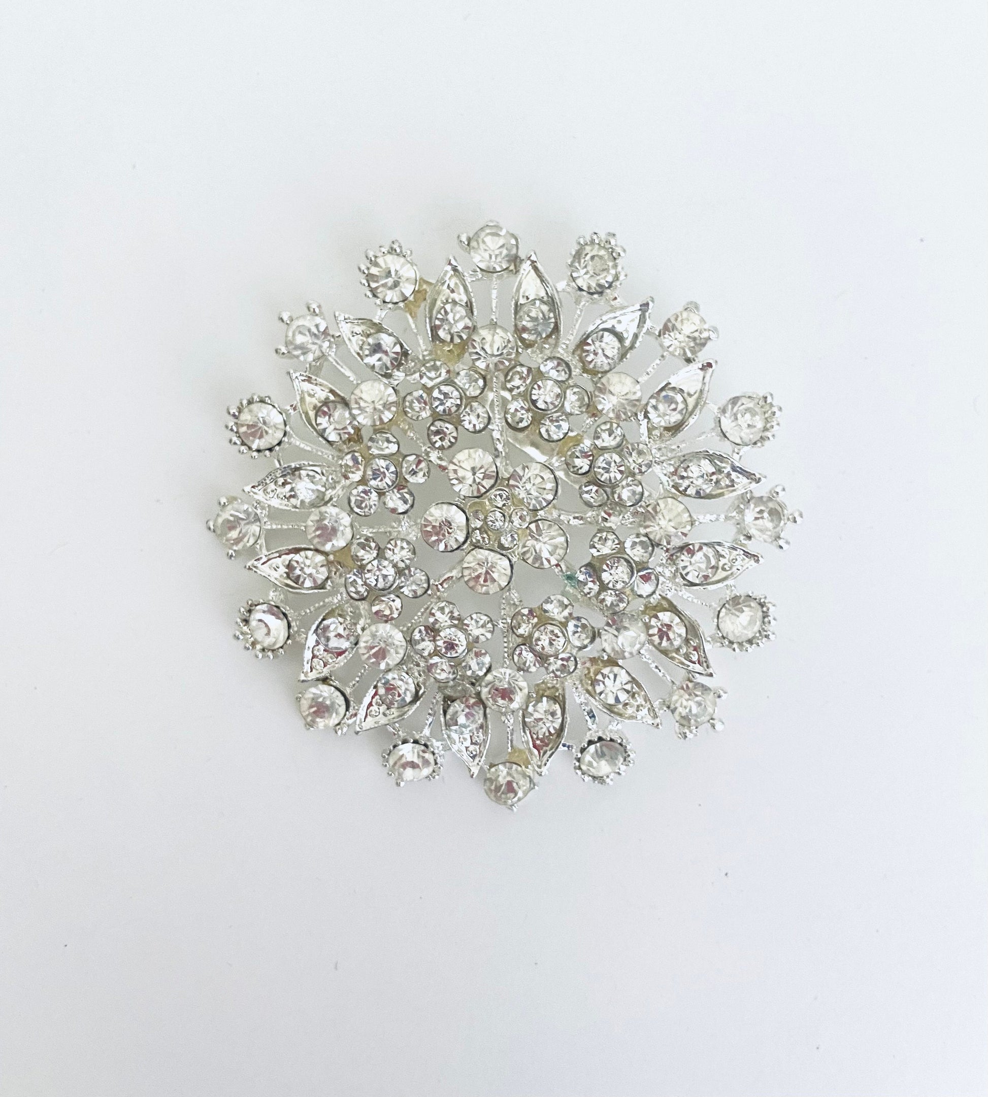 Silver brooch with crystal stones on a white background