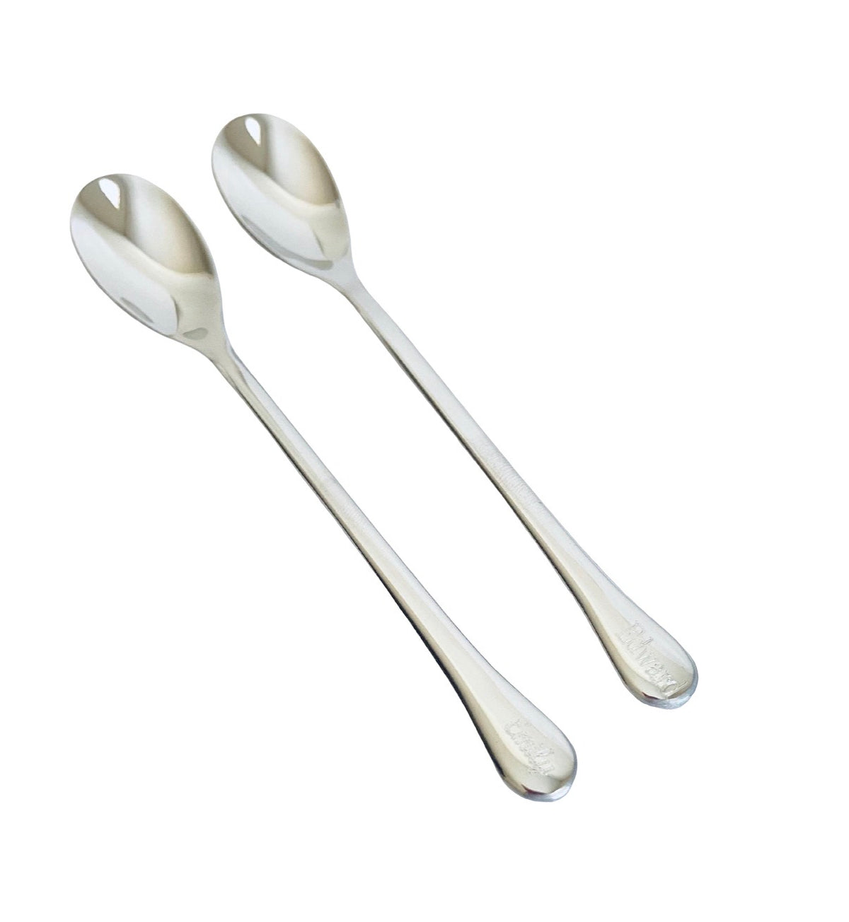 Two stainless steel spoons with long handles and oval bowls, arranged diagonally on a plain white background.