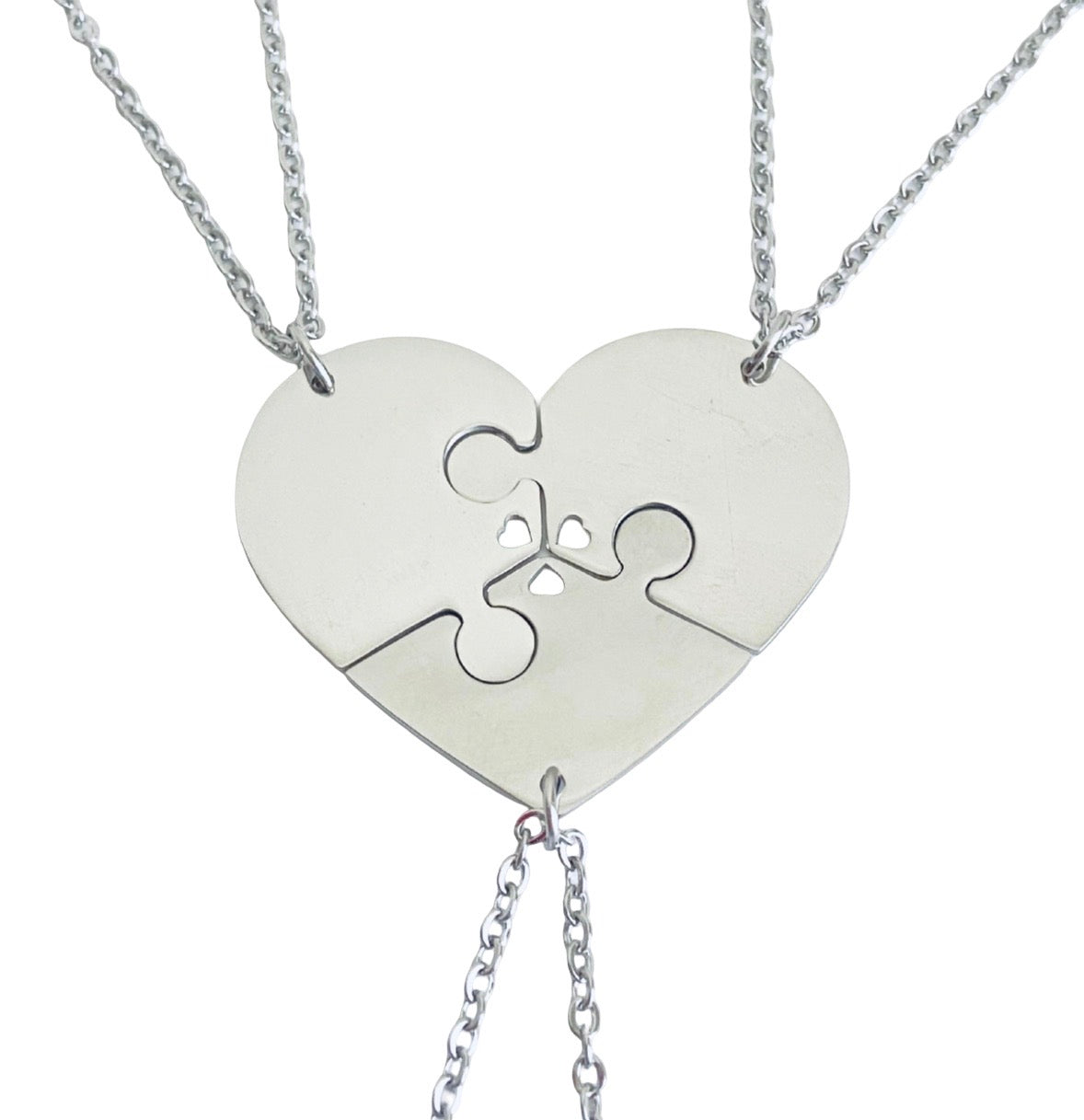 A three-piece silver puzzle heart pendant necklace on a matching chain, shown against a plain white background.