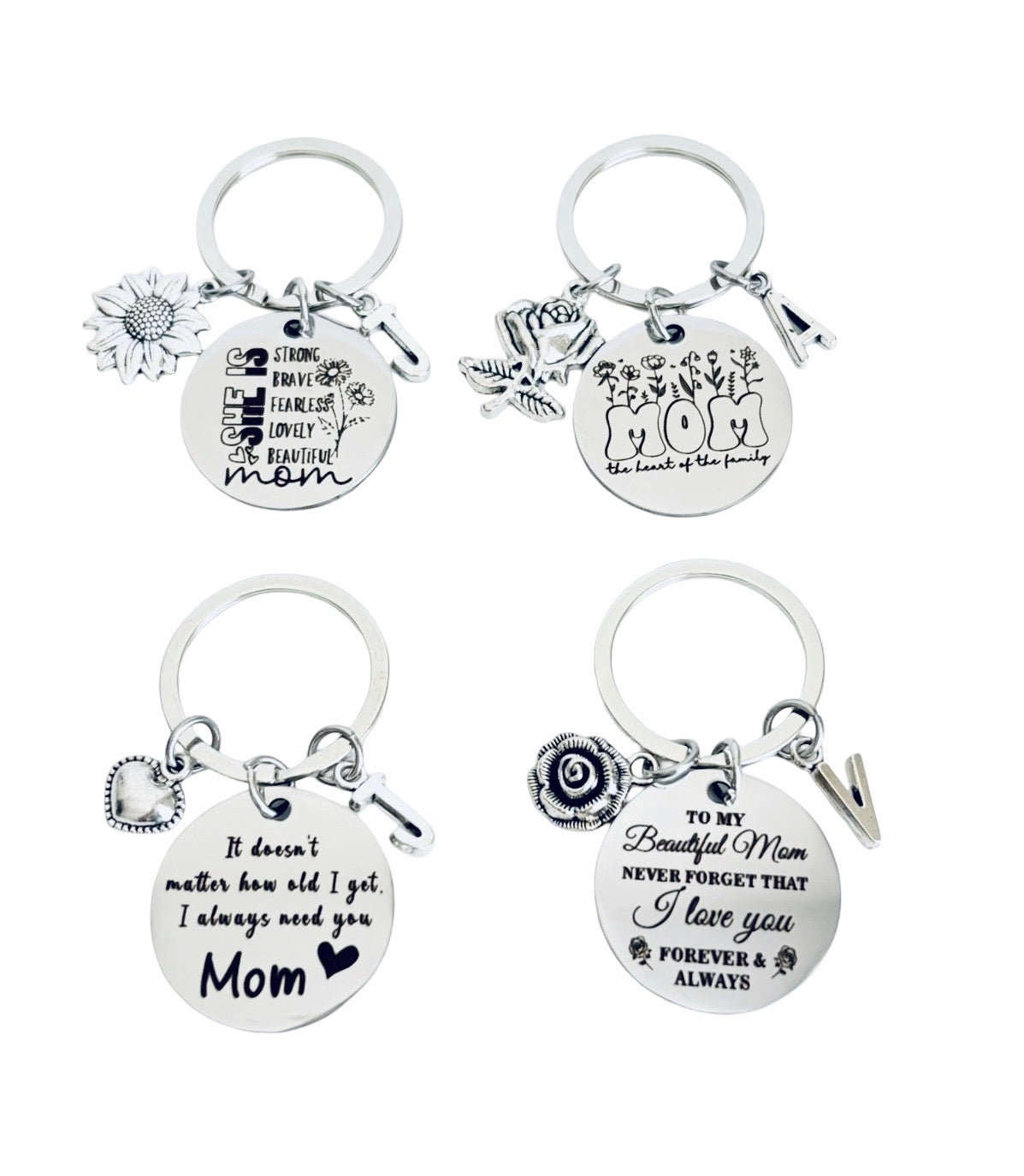 Four silver-toned metal keychains with engraved mother's day messages and small charms, arranged in a 2x2 grid on a plain white background.