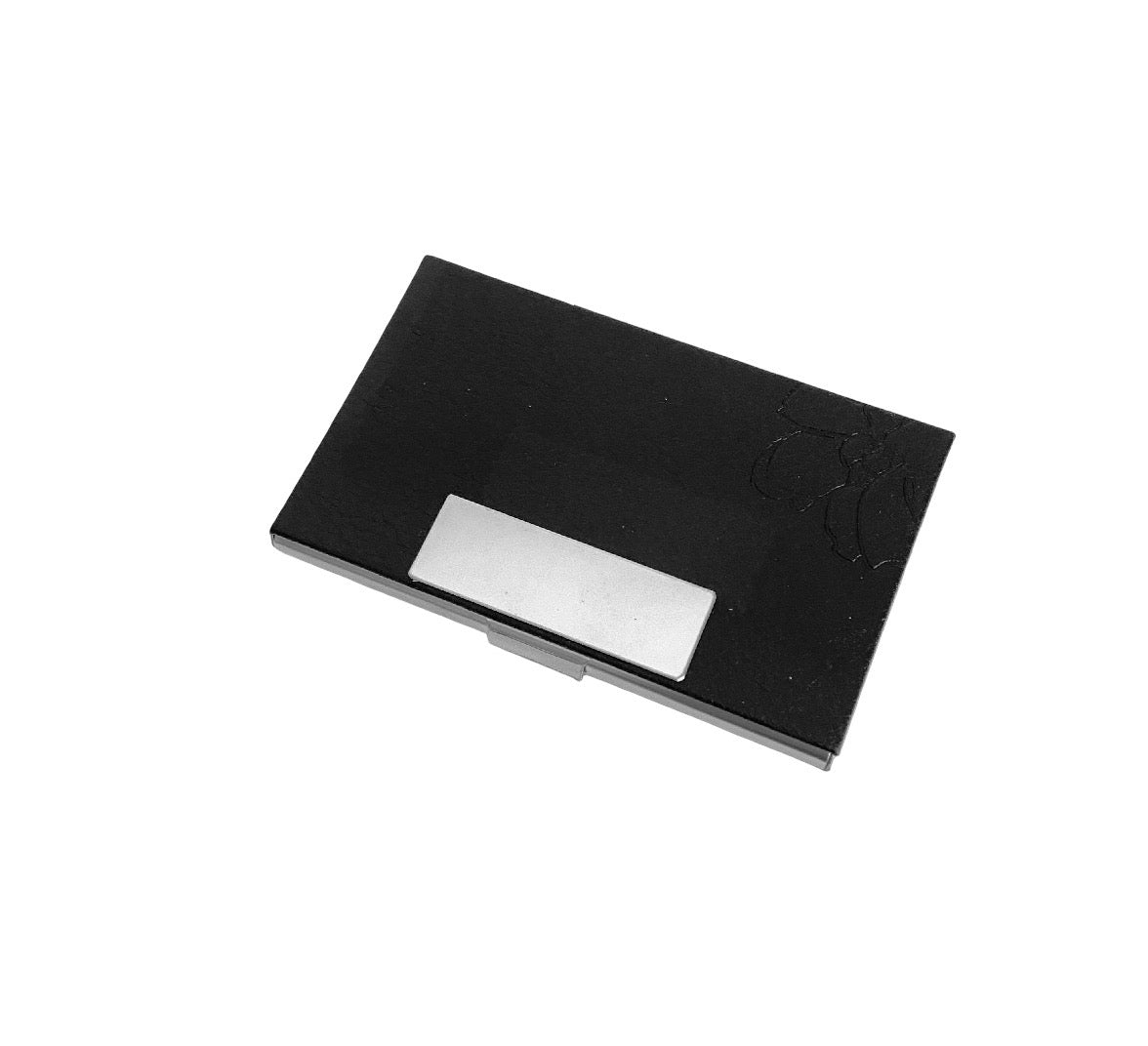 A black rectangular case with a silver metallic label area on the front, photographed on a plain white background.