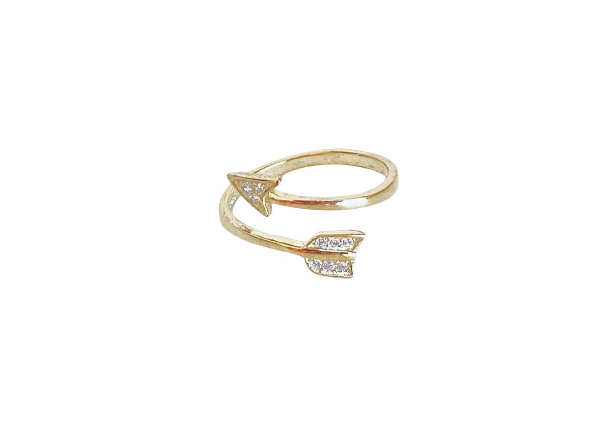 A gold arrow ring with small clear stones set along the arrowhead details, shown on a plain white background.