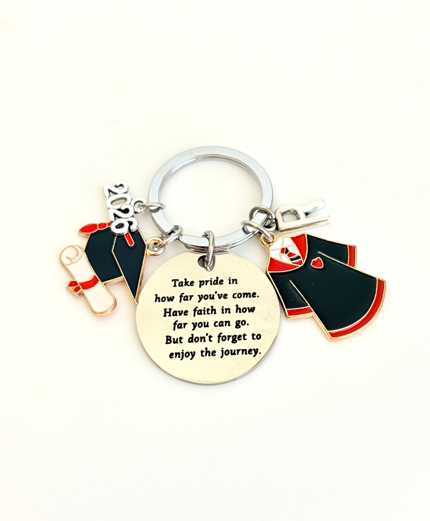 Keychain with graduation cap, gown, and diploma charms on a white background