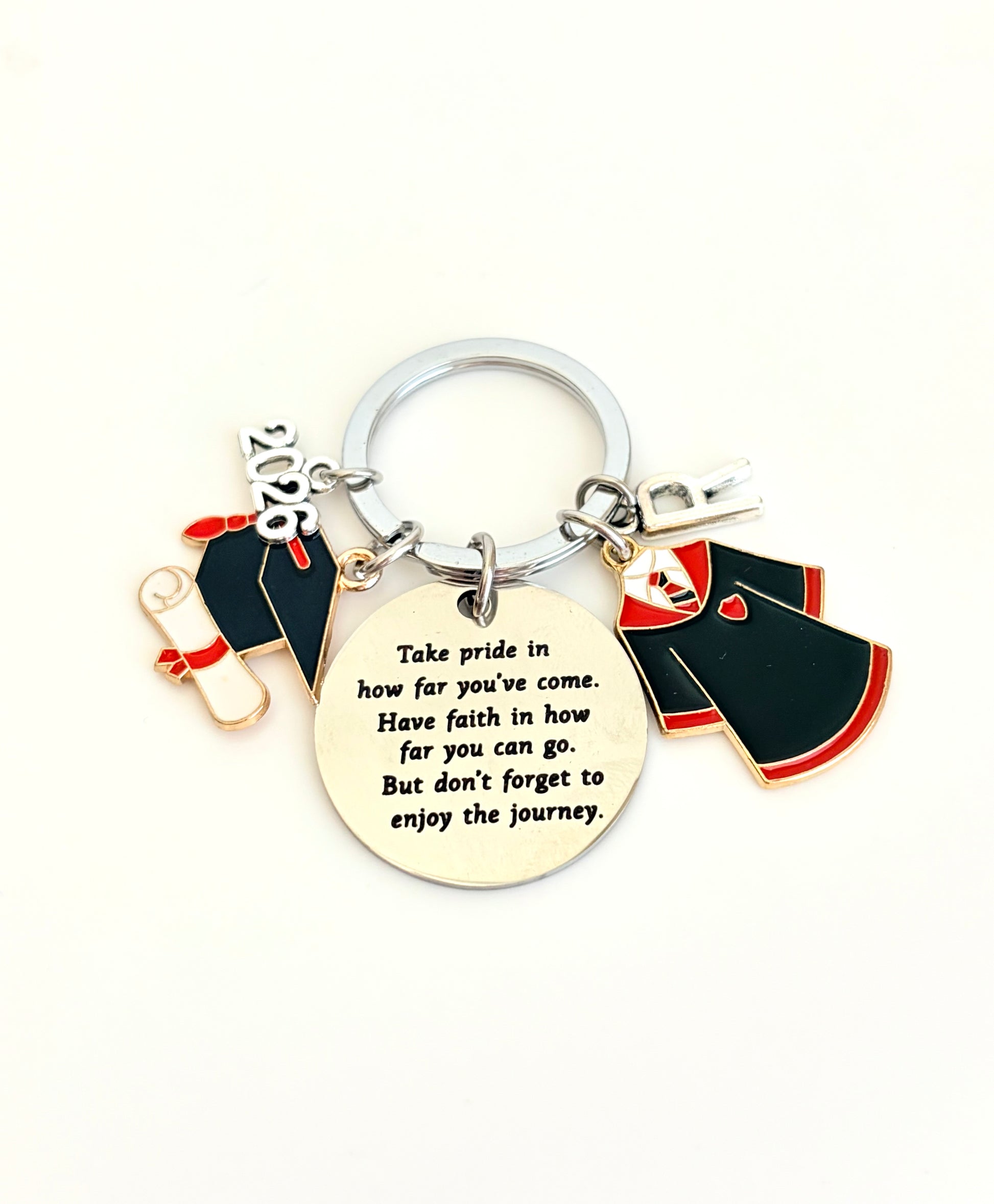 Keychain with graduation cap, gown, and diploma charms on a white background