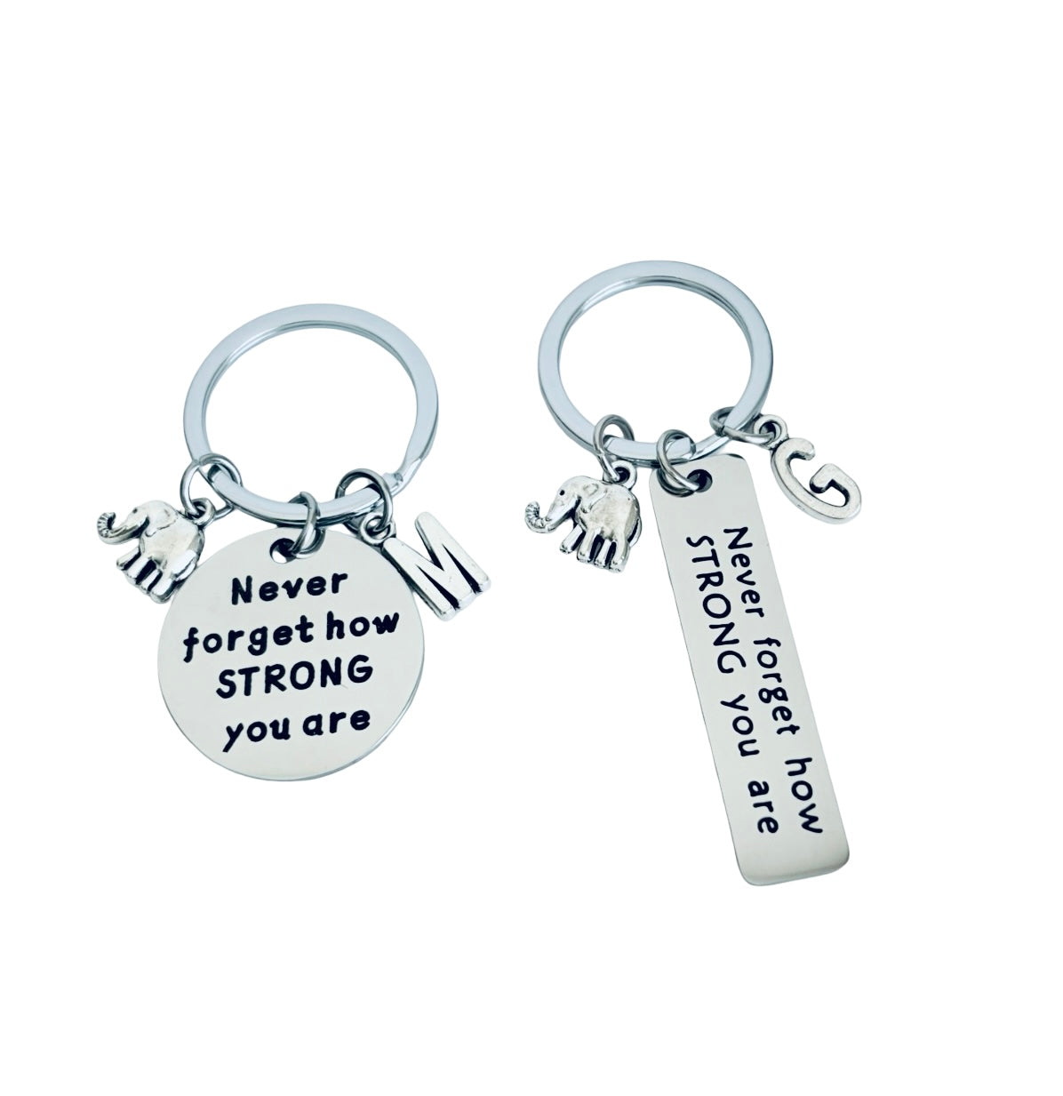 Two silver keychains with motivational phrases on a white background