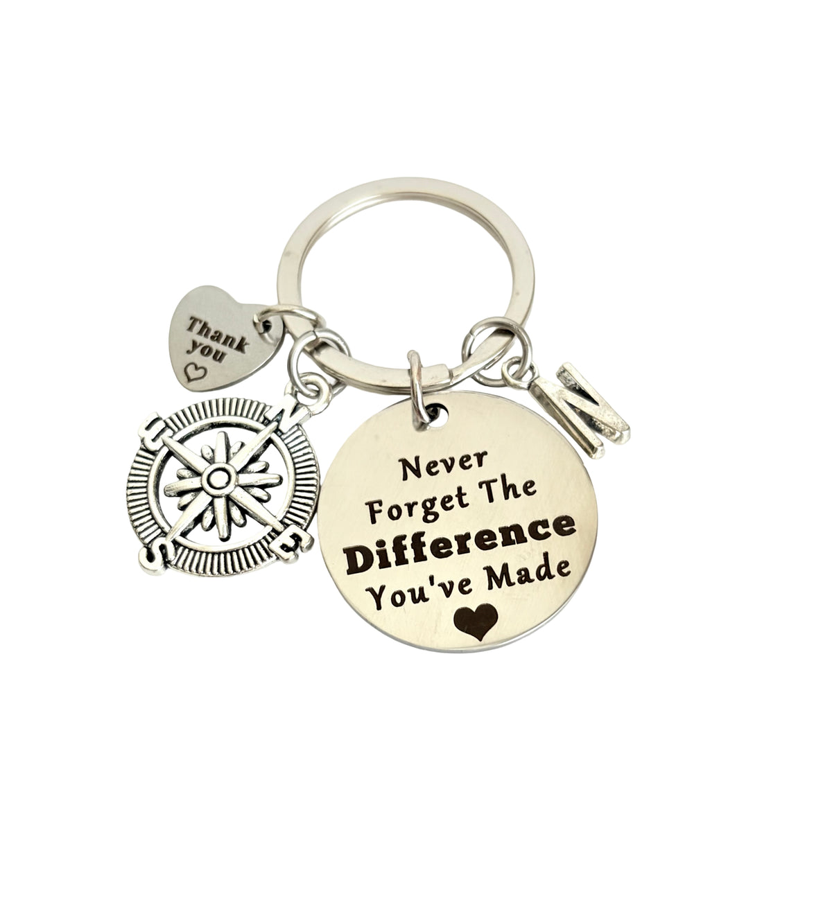 Keychain with compass charm and motivational tag on a white background
