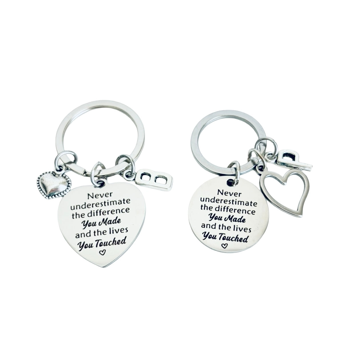 Two silver keychains with heart-shaped pendants and engraved text on a white background.