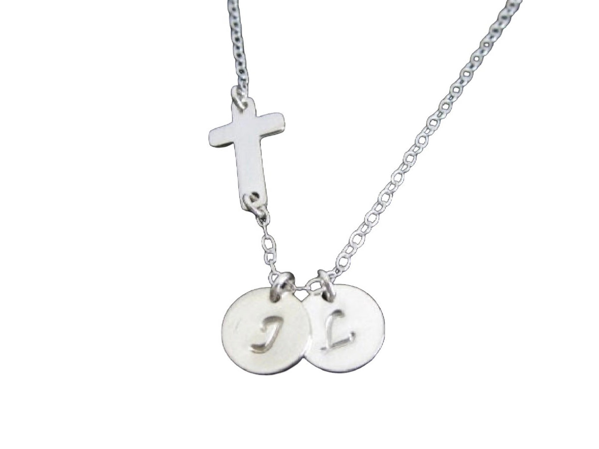 A silver chain necklace featuring a small cross charm and two round disc pendants engraved with the letters 'J' and 'H', shown on a plain white background.