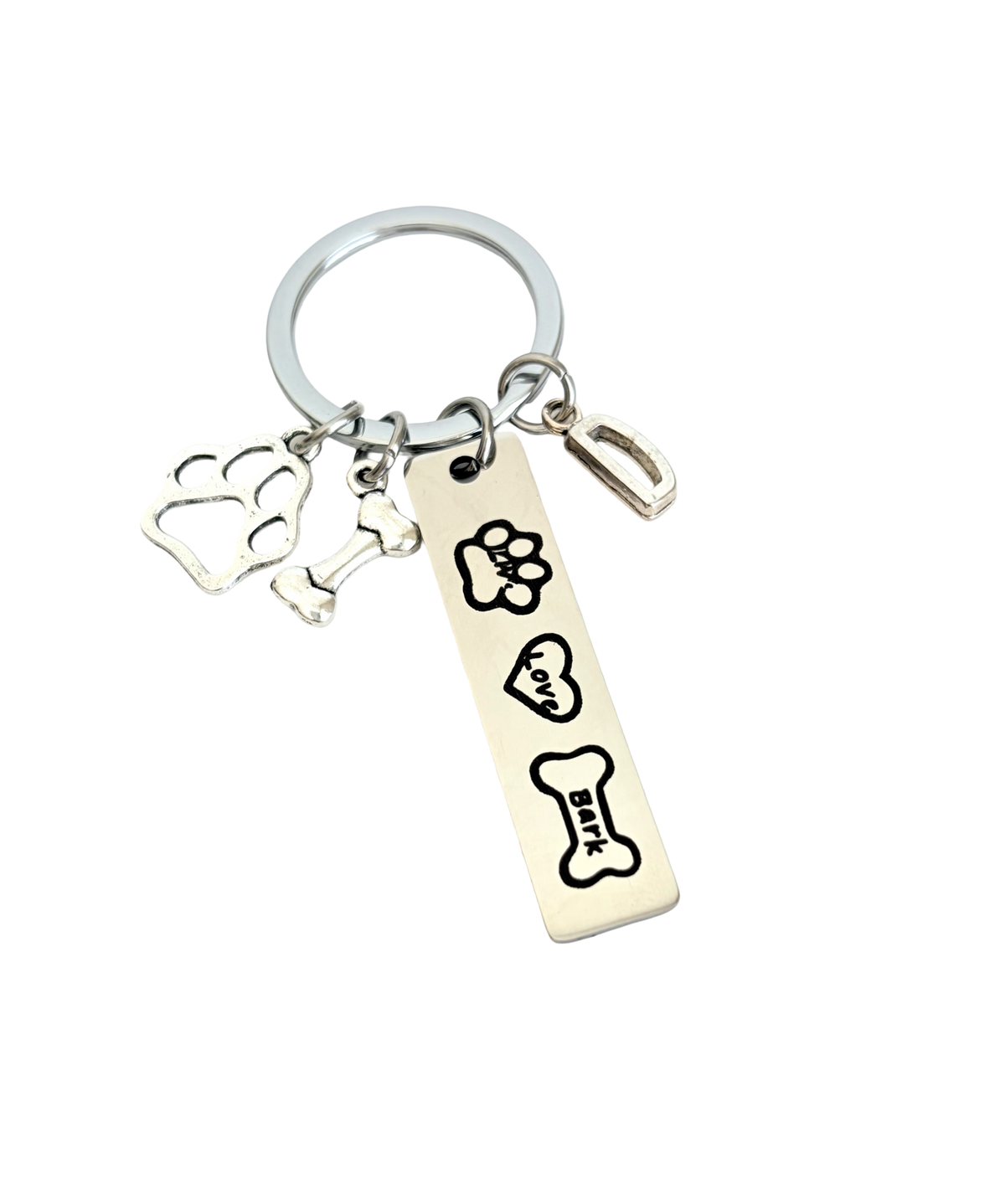 Keychain with paw print, bone, and flower charms on a white background