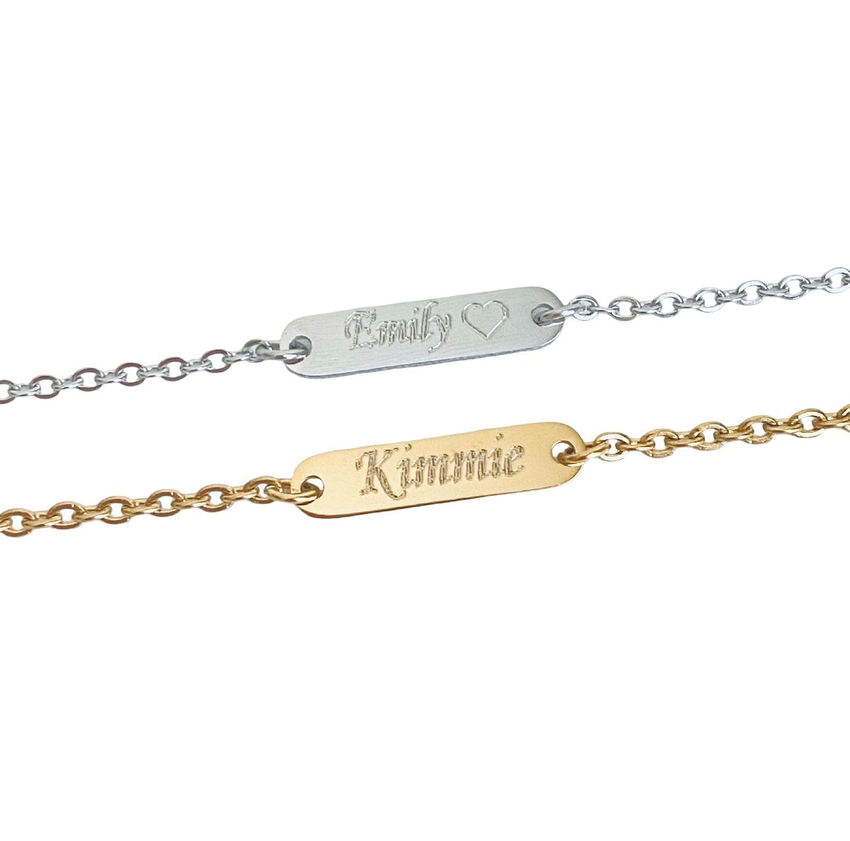 Two personalized name bracelets shown on a plain white background: one silver chain with a silver oval plate engraved 'Emily' and a heart, and one gold chain with a gold oval plate engraved 'Kimmie'.