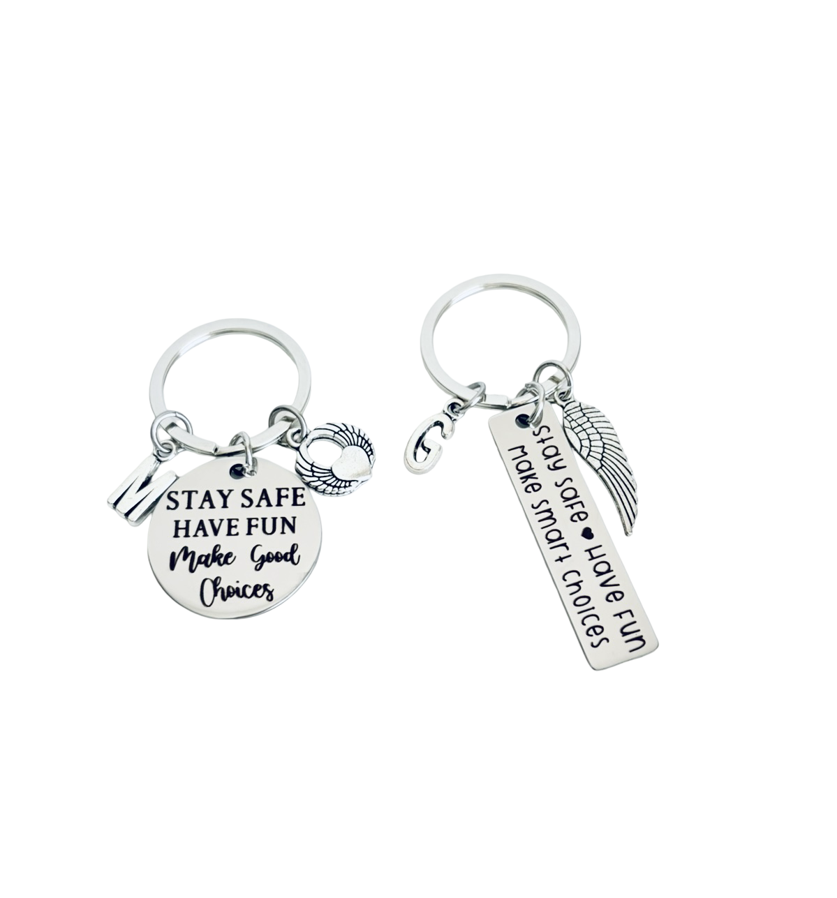 Two silver keychains with motivational phrases on a white background