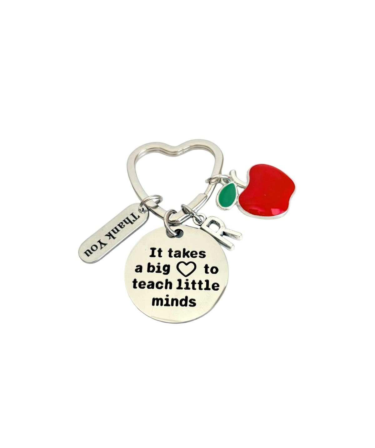 Keychain with heart-shaped charm, apple, and round tag with text on a white background