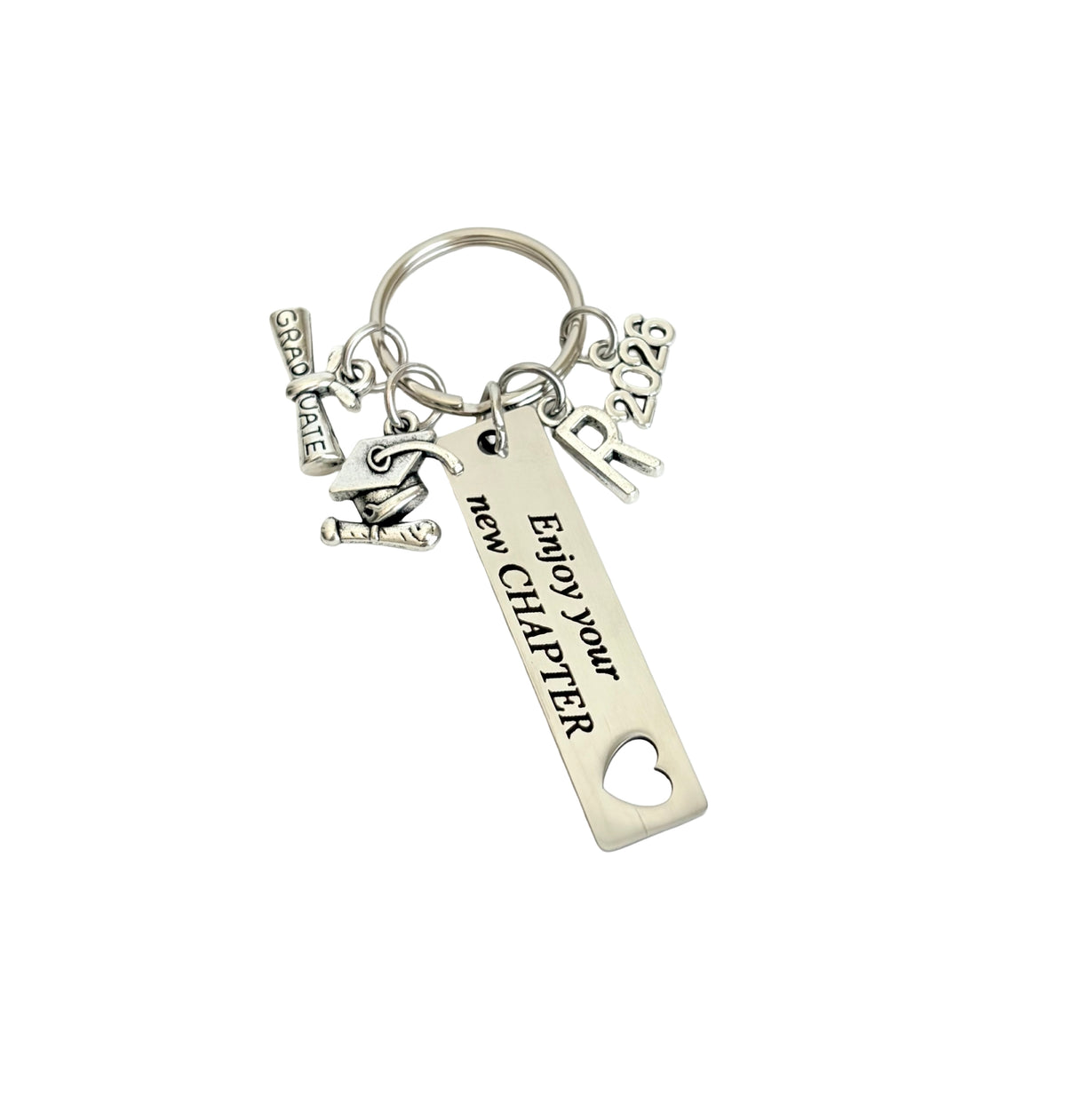 Silver keychain with 'Enjoy your new chapter' tag and various charms on a white background