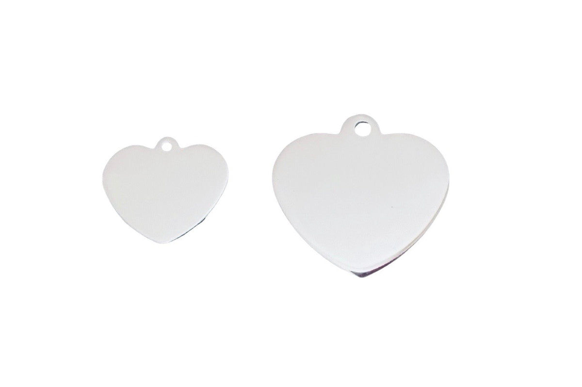 Two blank, polished silver heart-shaped metal tags with hanging loops, shown on a plain white background.