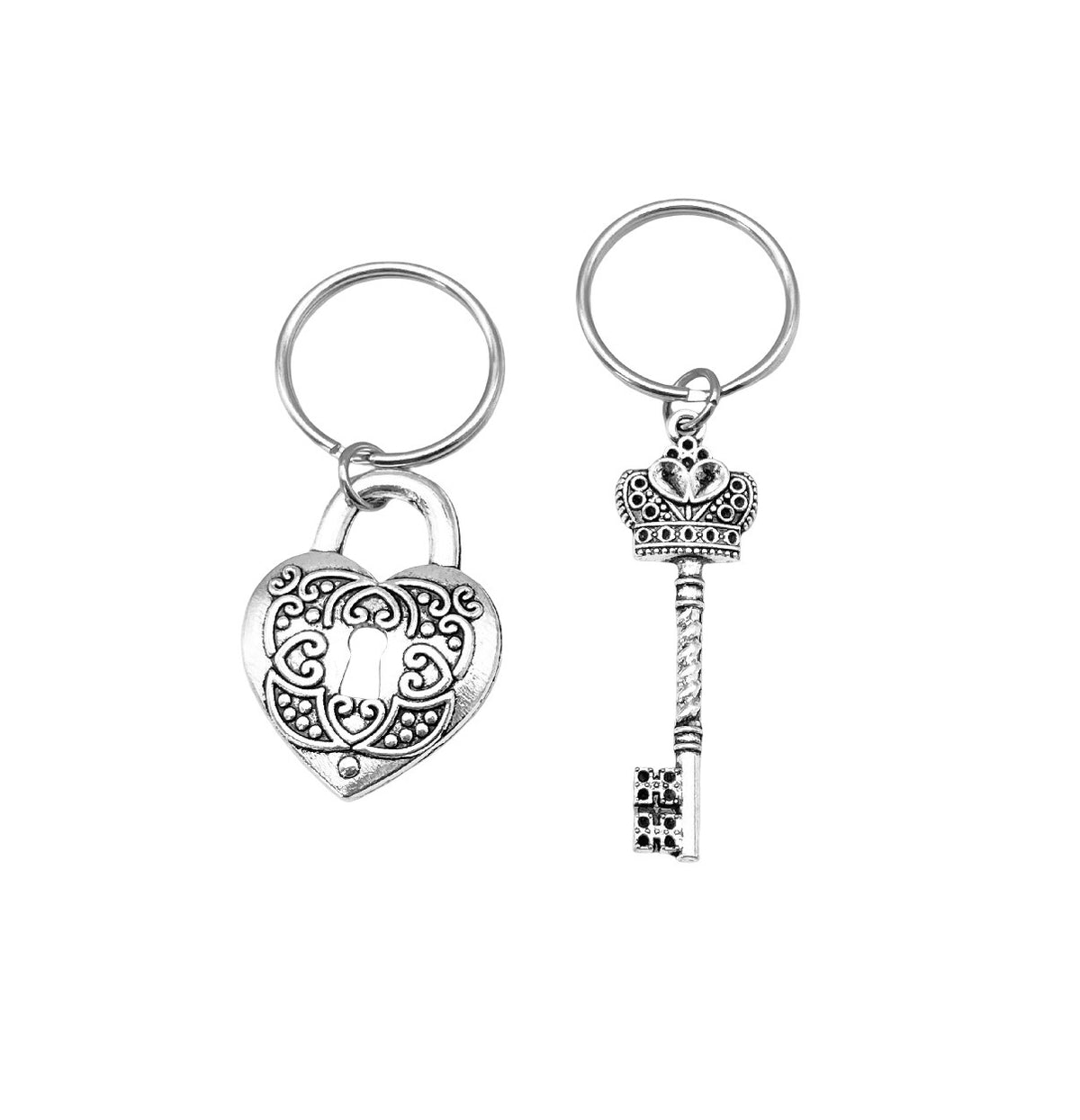 A pair of silver-toned metal keychains on a plain white background. One keychain features an ornate heart-shaped padlock charm with a keyring, and the other features a decorative crown-shaped key charm with a keyring.