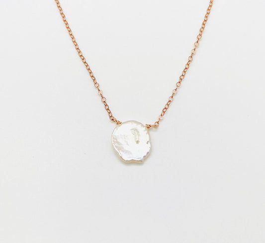 Necklace with a white pendant on a light gray background
