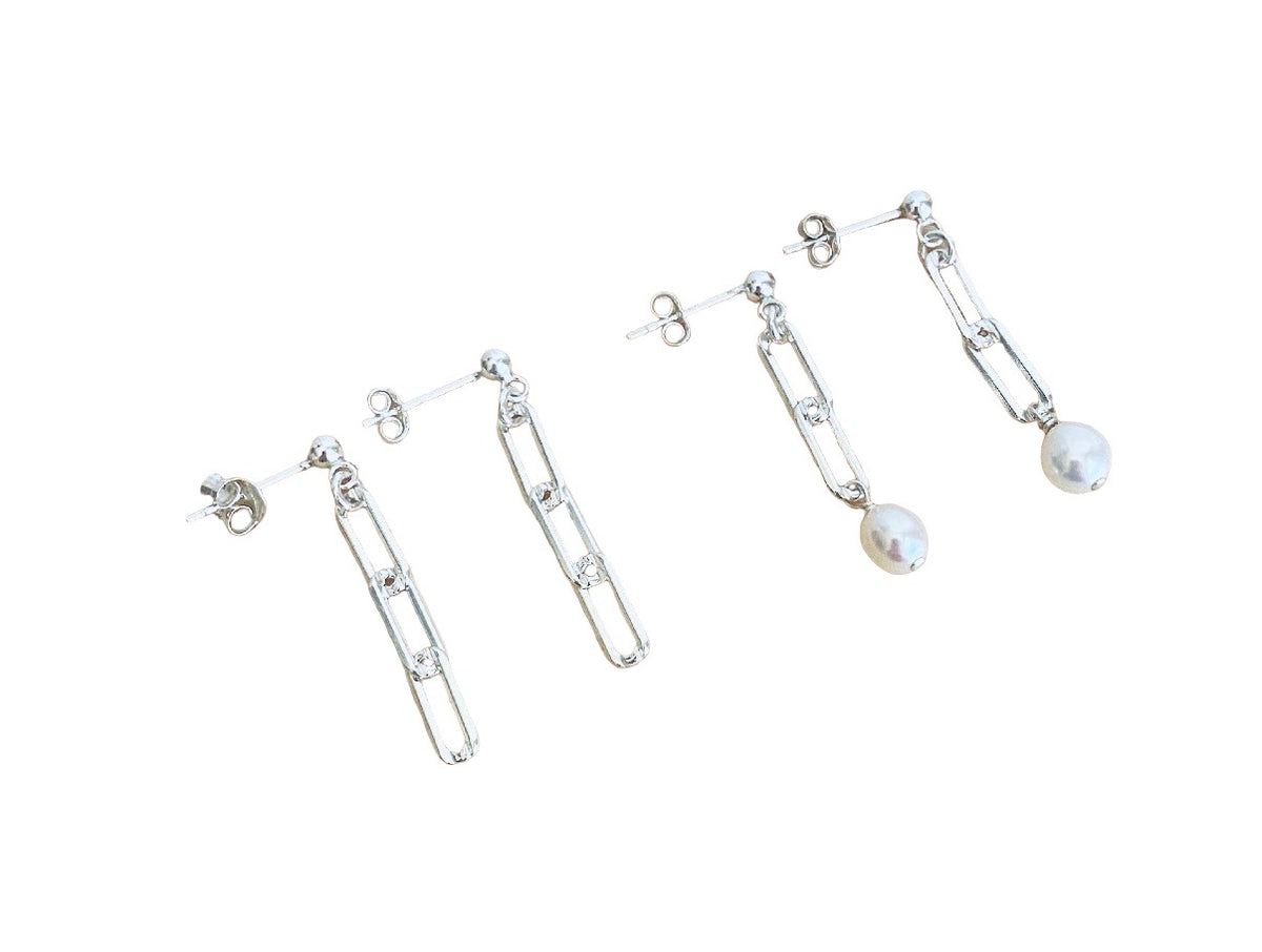 A pair of silver-toned drop earrings with elongated geometric link shapes and a single round white pearl dangle on each earring, shown on a plain white background.